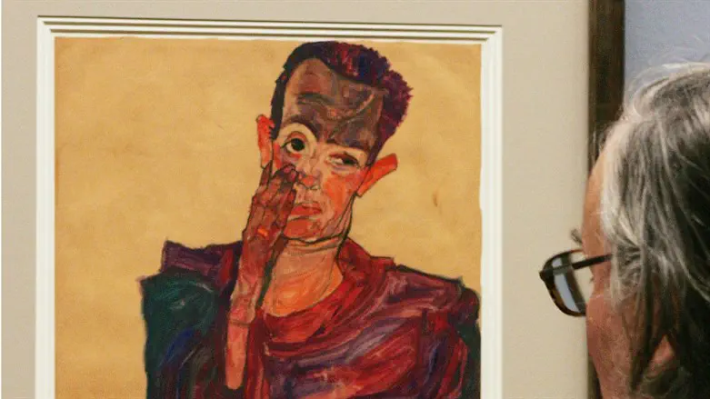 A visitor looks at painter Egon Schiele's "Self-Portrait with Lowered Eylid" from 1910