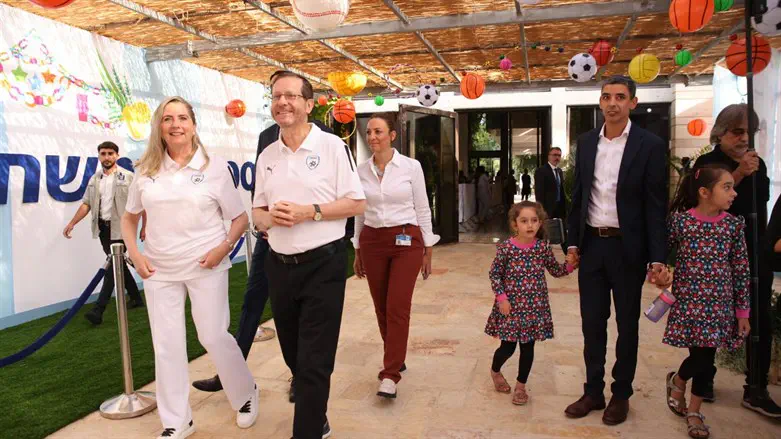 President Herzog and his wife in their sukkah