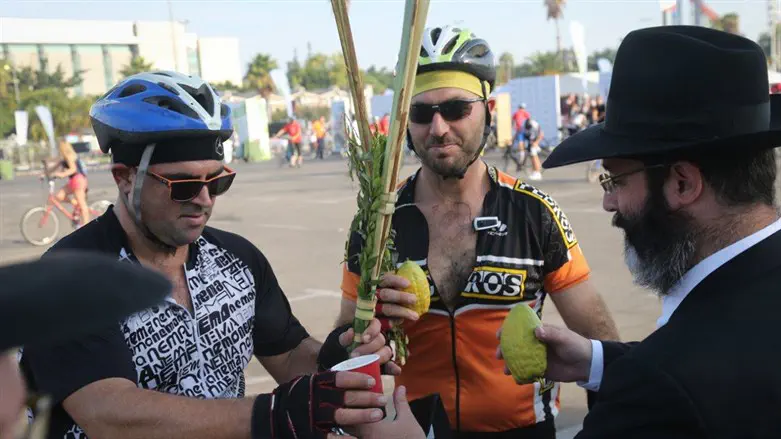Chabad shluchim help bike riders with Four Species on Sukkot