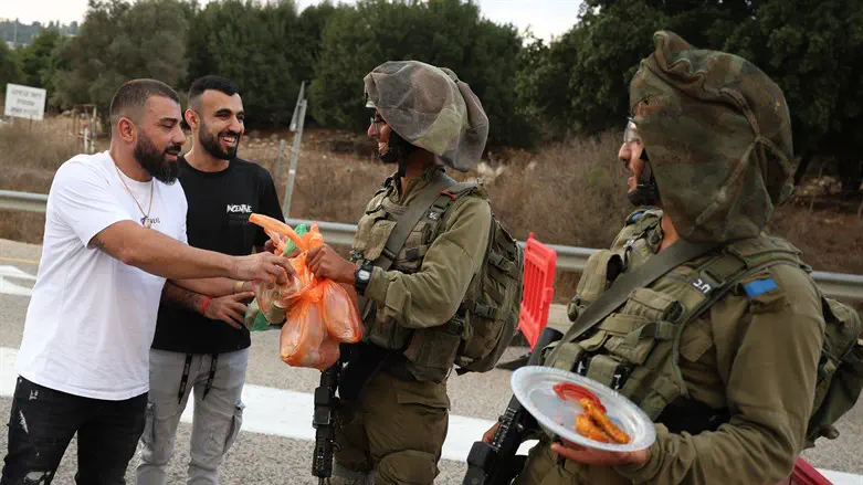 מתנדבים מחלקים אוכל ללוחמים