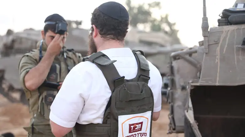 חסיד חב"ד מניח תפילין ללוחם בשטח