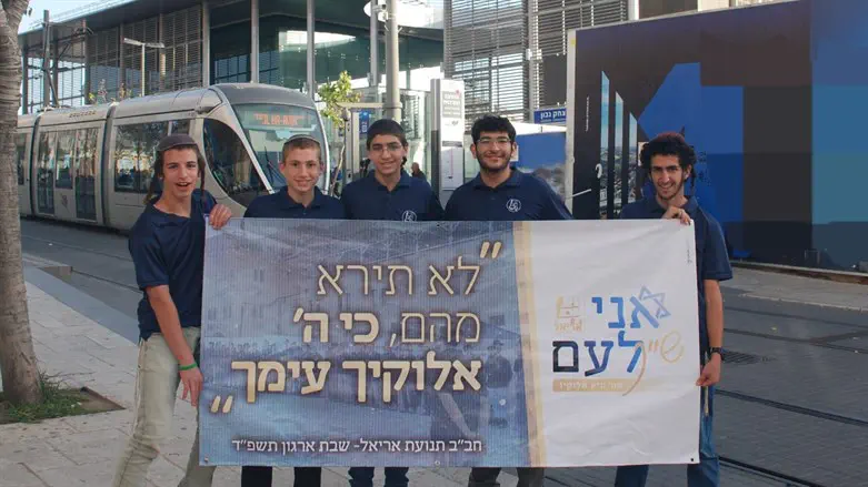 חניכי תנועת אריאל עם אחד השלטים שתלו