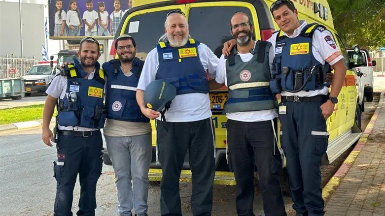 Am Yisrael Chai Foundation chairman Shmuel Sackett (center) with the new ambulance