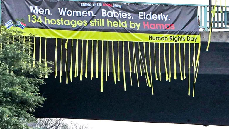 Bring them home now banner over highway