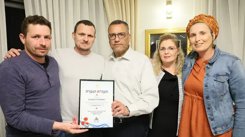 ליאון מעניק את התעודה לבני משפחת הרשקוביץ