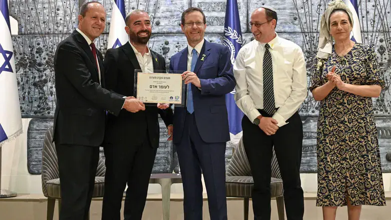 עומר אדם מקבל את תעודת ההוקרה