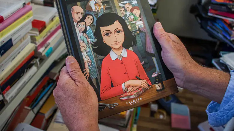 A man holds a copy of the graphic novel version of "The Diary of Anne Frank"