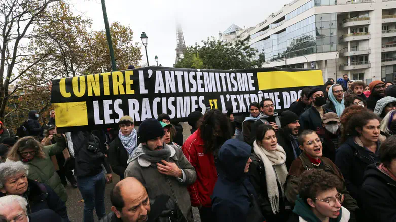 Demonstrators carry a banner reading, "Against antisemitism, racism & the extreme right."