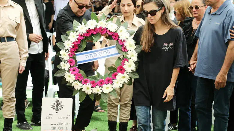 קים, רעייתו של דניאל אלוש, מניחה זר על קברו