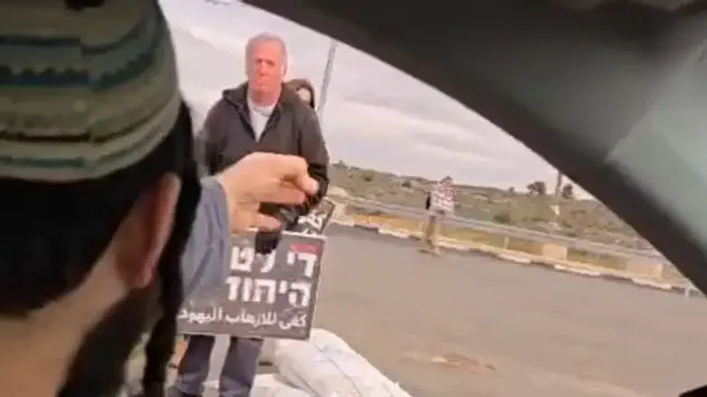 Succot, front, with protester, back