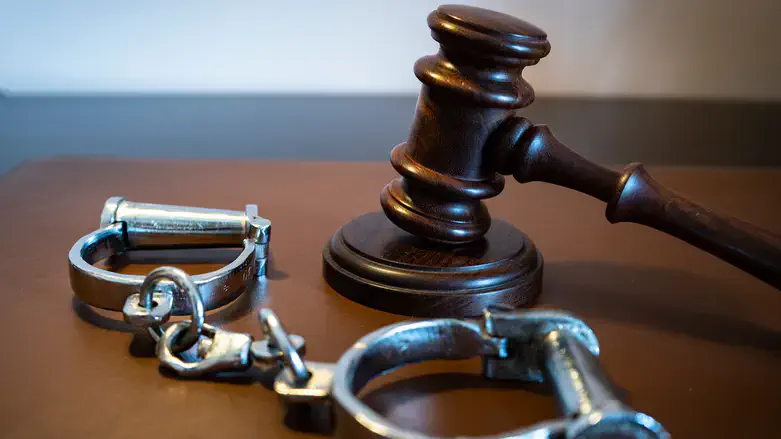 Gavel and handcuffs on a leather surface.