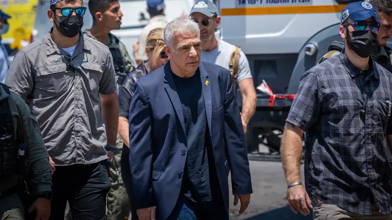 Yair Lapid visits missile impact site in Tel Aviv
