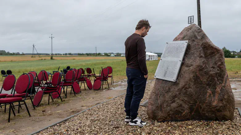 A man reads one of the plaques newly placed near Polish monument to the Jedwabne massacre.