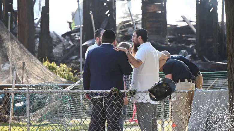 Rabbi Yitzchok Lerman, who survived with his family in the fire, by the synagogue's ruins