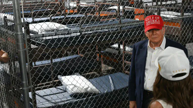 Donald Trump speaks with Kristi Noem as they tour a migrant detention center in Florida