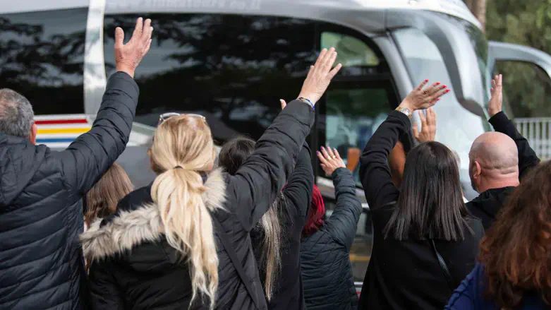 הורים מנפנפים לשלום לילדיהם שהתגייסו