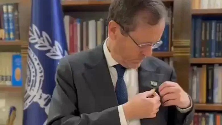 President Herzog removes hisyellow ribbon pin