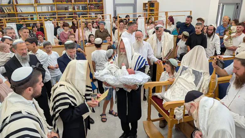 הרב דודי אוחז את התינוק