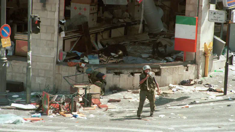 Israeli soldiers check for explosives at the site of the Sbarro terror attack