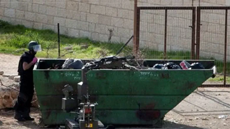 Police sapper inspects garbage bin