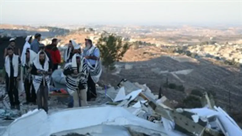 מתפללים לצד ההריסות