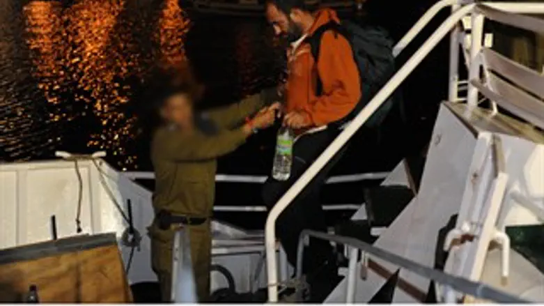 קצין חיל הים עוזר לפעיל המשט לרדת מן הספינה