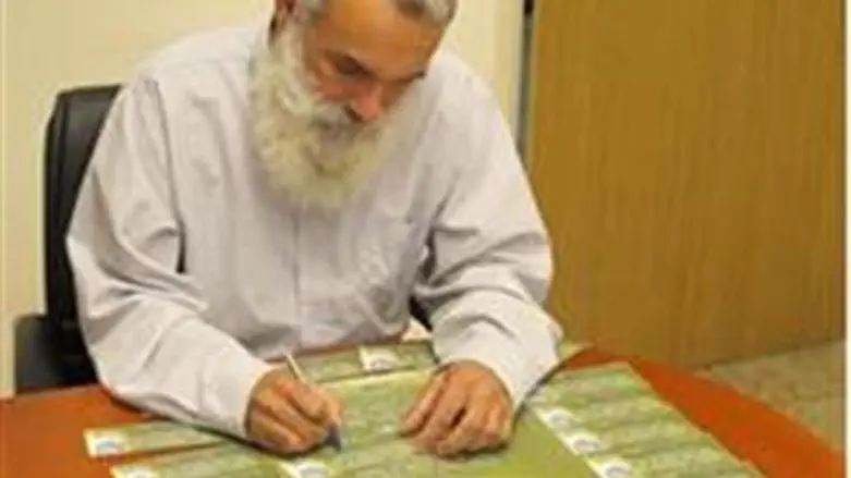 Rav Ronsky signs a card.