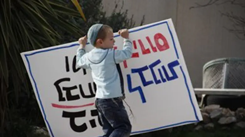 ילד עם שלט נגד ההרס במגרון