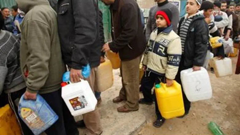 Gaza Arabs wait to fill containers with fuel
