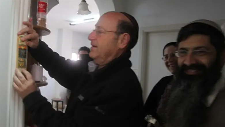 MK Schneller places mezuzah on new Hevron Jew