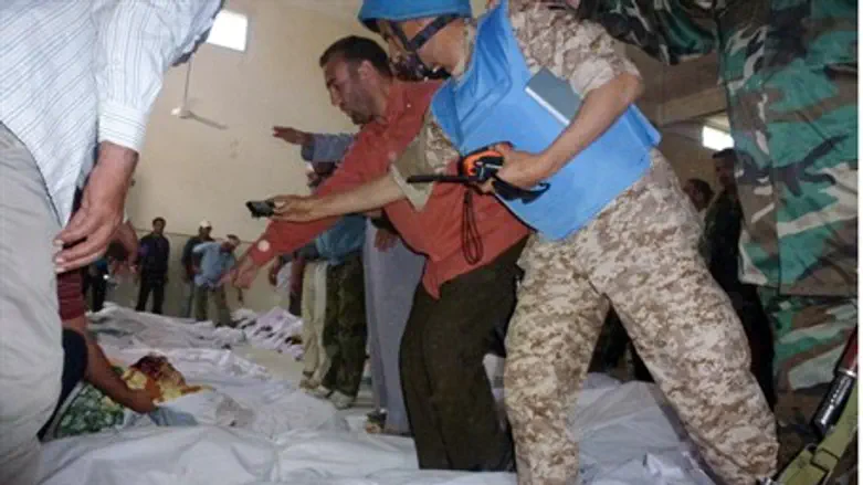 A U.N. observer takes pictures of bodies of p