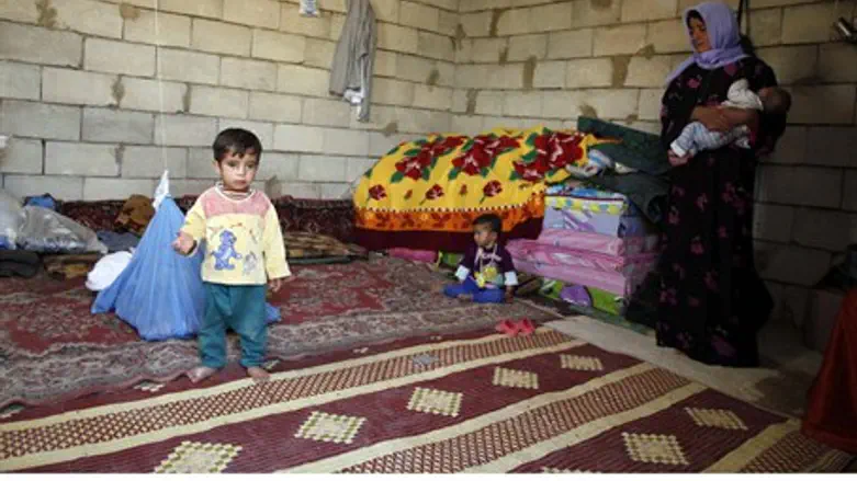 Syrian refugees sit in a temporary home in Le