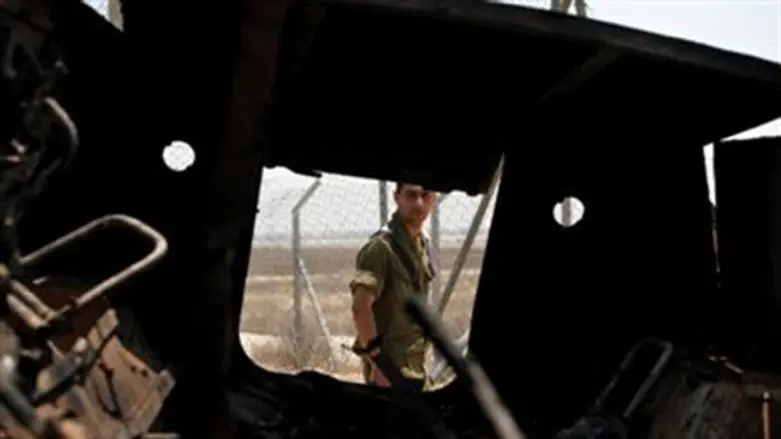 An Israeli soldier walks past a burned Egypti