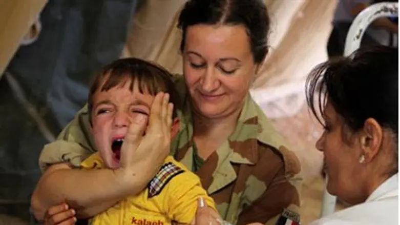 A Syrian boy cries as he gets an inoculation
