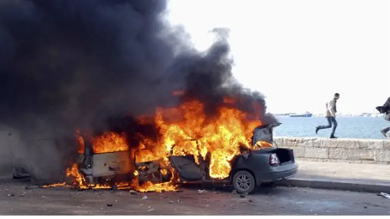 Anti-Morsi protesters run in front of burning