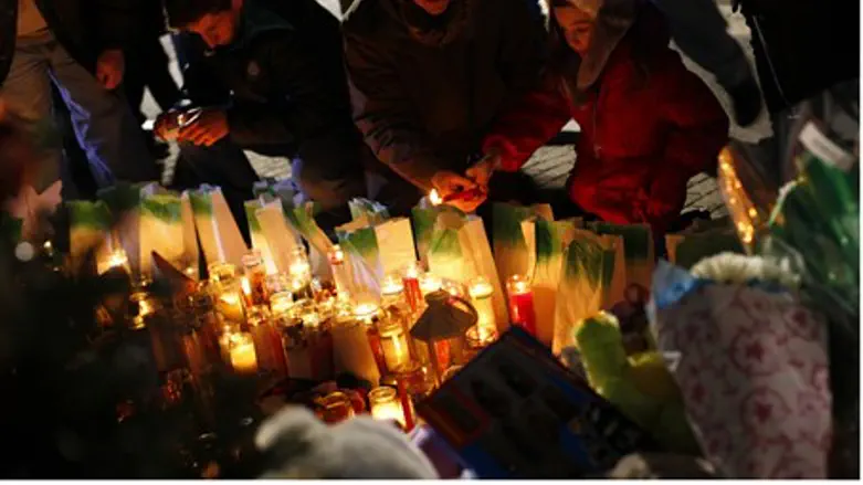 People light candles at a memorial for Sandy 