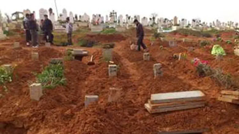 Syrian residents look at fresh graves