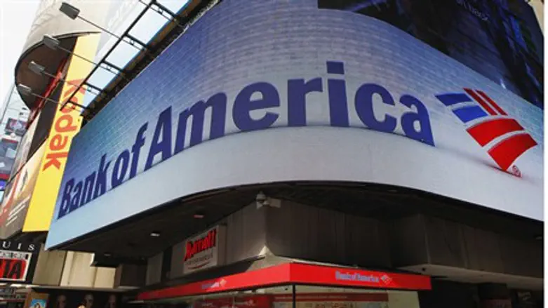 Tourists walk past a Bank of America banking 
