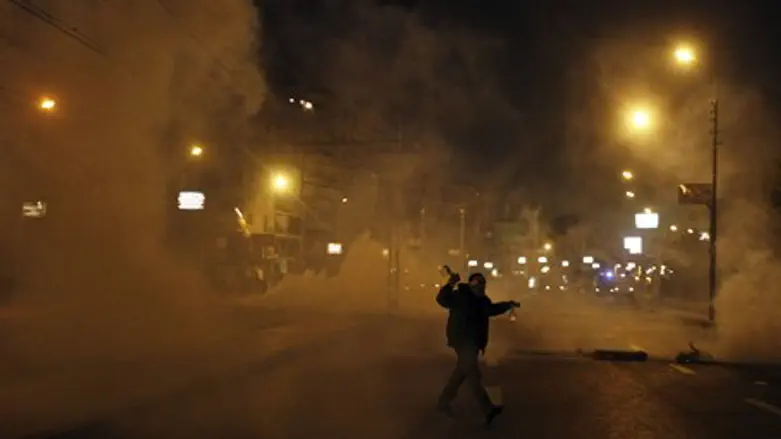 Protester flees from tear gas in front of the