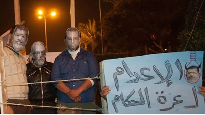 Protesters wear masks of Morsi and other Egyp