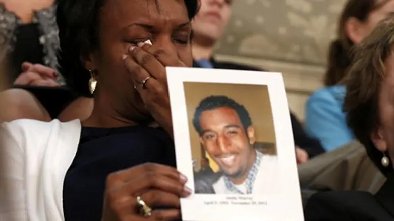 A relative wipes away a tear as she holds up