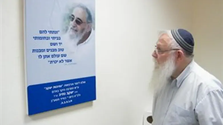 הרב דרוקמן מתבונן בתמונת הרב נתיב