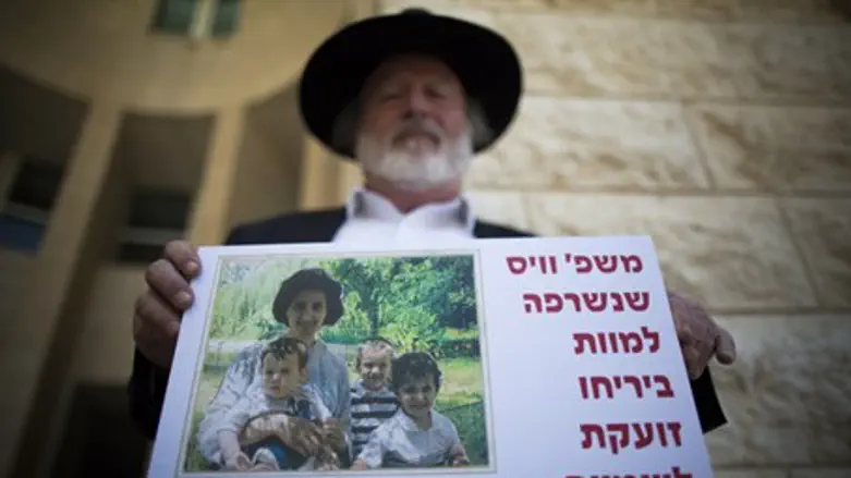 Protester holds picture of the Weiss family