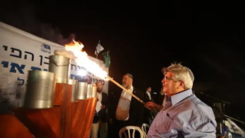 Chaim Fogel lights hannukah flame at inaugura