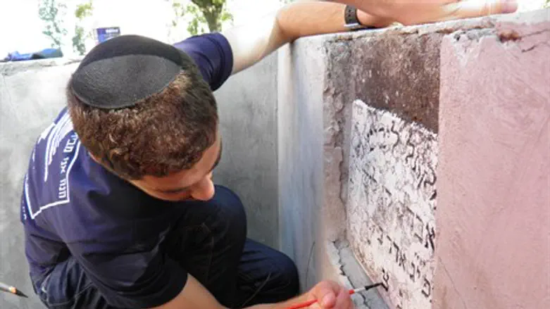 Bnei Akiva volunteer repairs tombstone