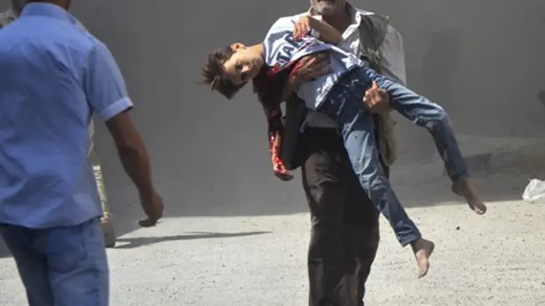Syrian man carries wounded boy (file)