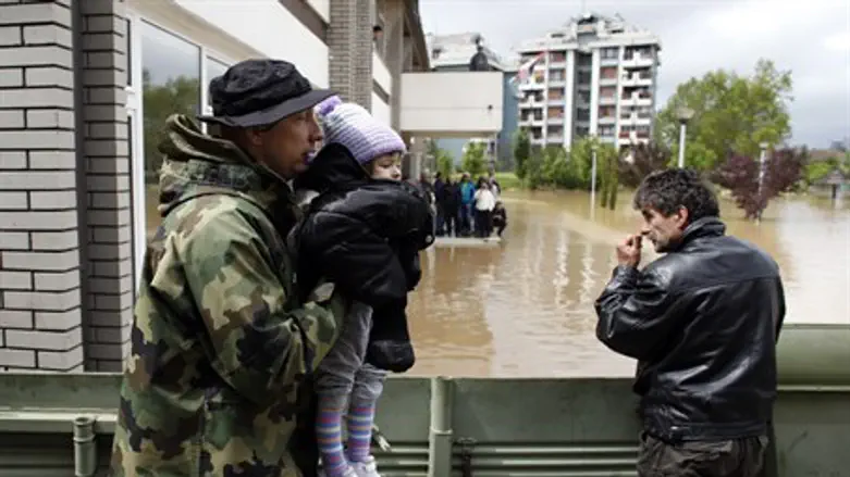 Serbian soldier evacuates child from flooding