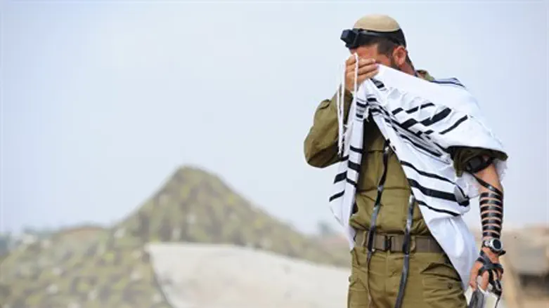 IDF soldier prays near the front line, close 