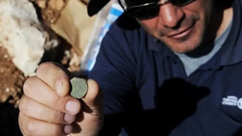 הארכיאולוג פבלו בצר עם מטבע משנת 4 למרד