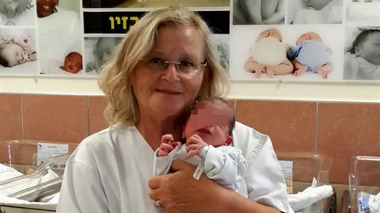 אחות אחראית מחלקת ילודים עם התינוקת.